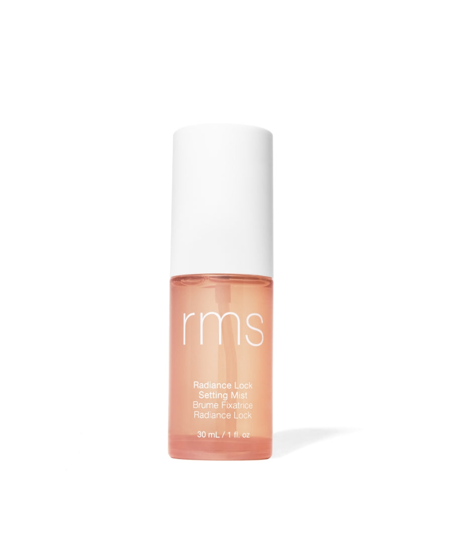A small clear bottle with pale peach liquid and white cap labeled RMS Beauty Radiance Lock Setting Mist, a clean beauty makeup setting spray with natural ingredients.