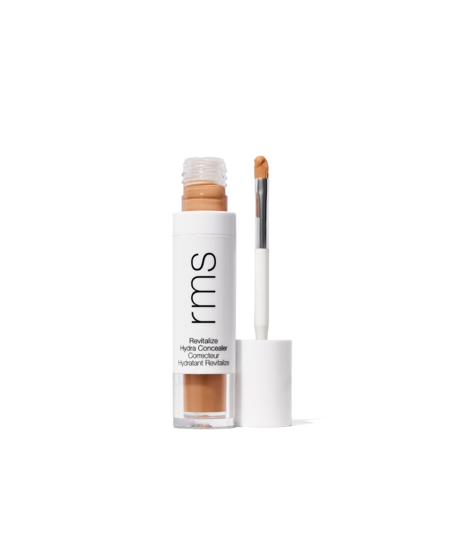 Open tube of Revitalize Hydra Concealer with visible applicator wand showing creamy natural beige concealer, packaged in recyclable white and clear container.