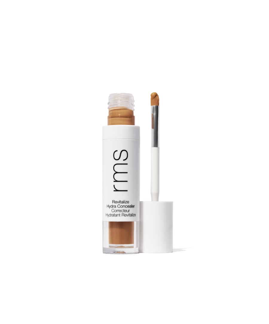 Open tube of Revitalize Hydra Concealer showing light medium tan shade with attached brush applicator against a white background in recyclable packaging.