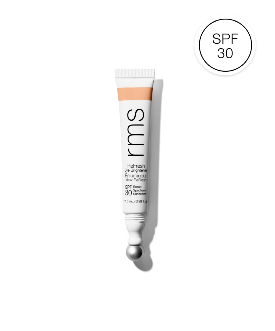 Tube of ReFresh Eye Brightener Broad Spectrum SPF 30 + Correcting Tint with metal applicator ball, showcasing clean beauty and skincare infused makeup qualities.