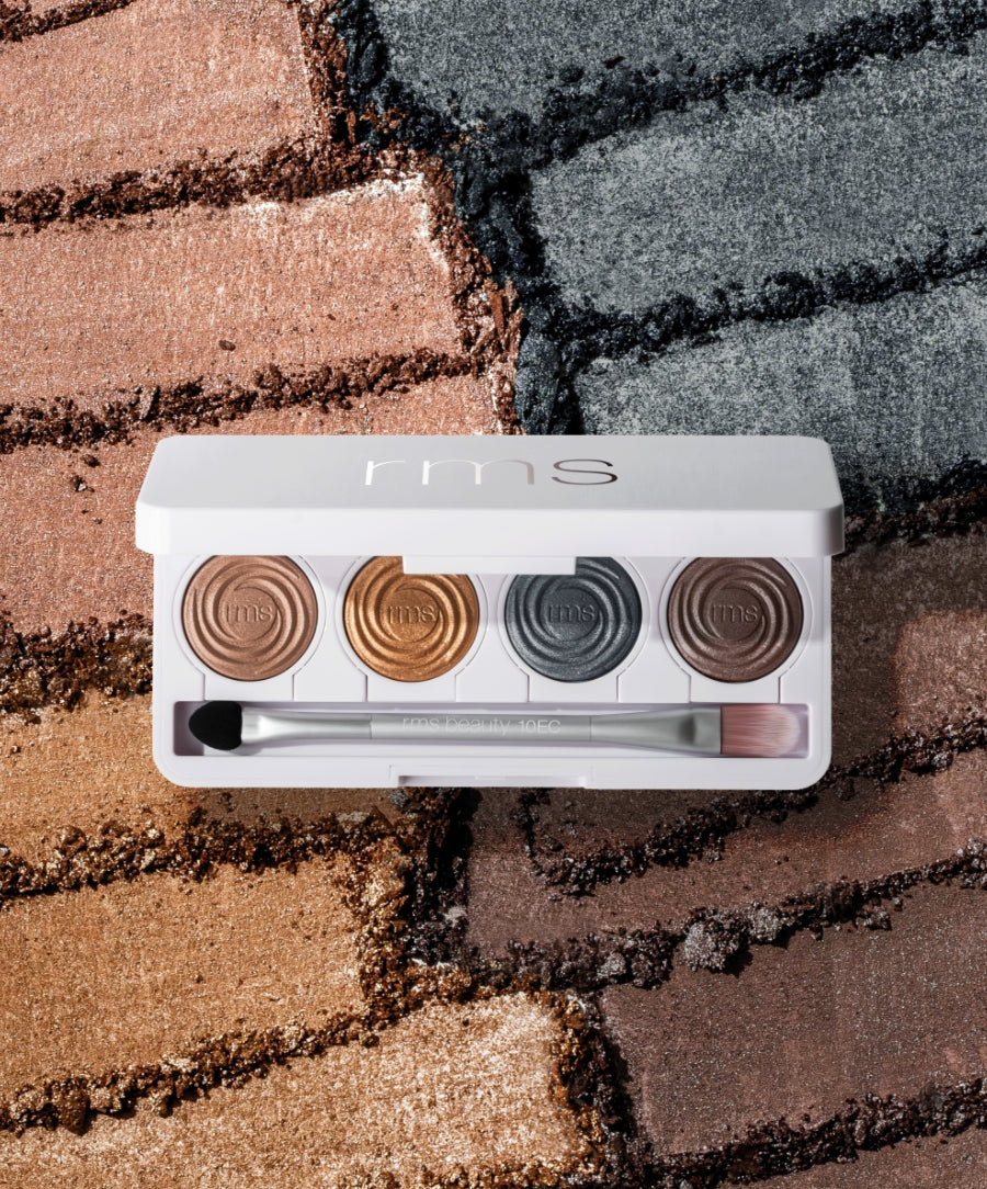 ReDimension Hydra Eyes Quartet eyeshadow palette featuring four shimmer shades in warm brown, gold, charcoal, and deep brown with a dual-ended brush on textured eyeshadow swatches background.