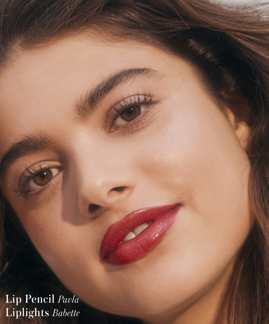 Close-up of a woman wearing vibrant red Liplights Cream Lip Gloss with natural makeup, highlighting smooth skin and glossy lips for a clean beauty look.