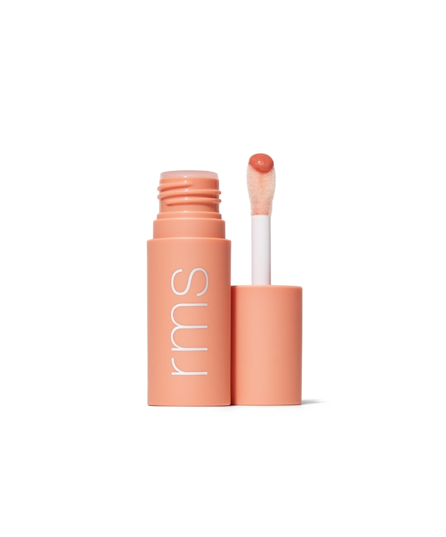 Open tube of Legendary Lip Oil with peach-toned applicator displaying a glossy, natural lip oil formula in sustainable packaging designed for cruelty-free skincare infused makeup.