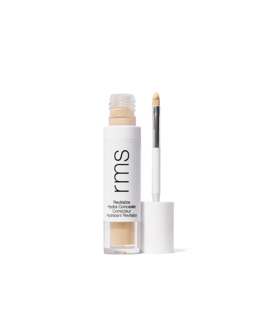 Open tube of Revitalize Hydra Concealer with beige cream visible, white cap with built-in applicator wand against a white background, showcasing clean and minimal design.