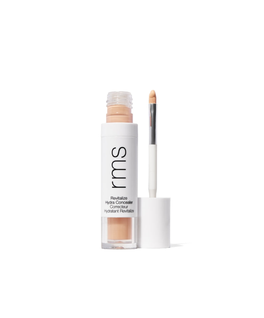Open tube of Revitalize Hydra Concealer with applicator wand showing smooth, creamy beige concealer in recyclable white and clear packaging designed for clean beauty and skincare infused makeup.
