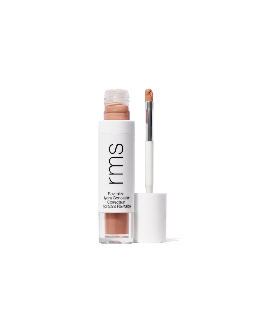 Open tube of Revitalize Hydra Concealer with doe-foot applicator showing natural beige liquid concealer in sleek white and clear packaging from RMS Beauty.