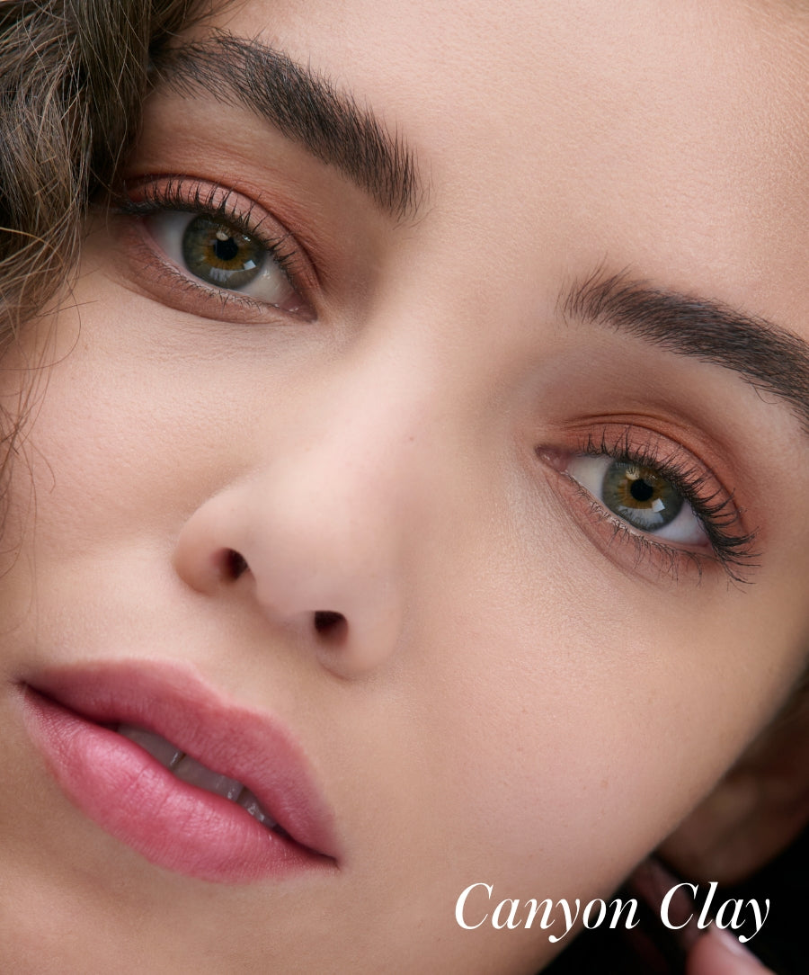 Close-up of a woman's face with soft, natural makeup highlighting her eyes in warm, earthy tones using Cashmere Matte Eyelights.