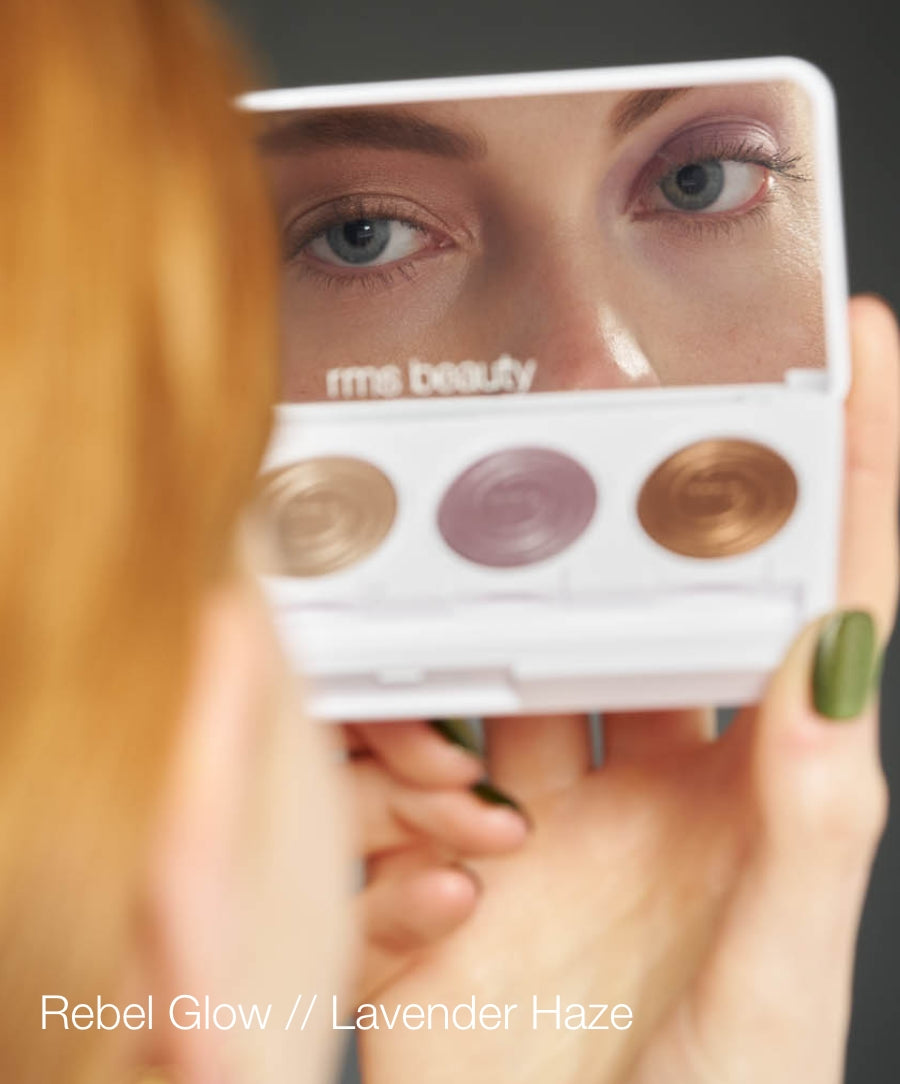 Close-up of a woman applying eyeshadow with the ReDimension Hydra Eyes Quartet palette featuring lavender and neutral shades, reflecting natural beauty and clean ingredients.