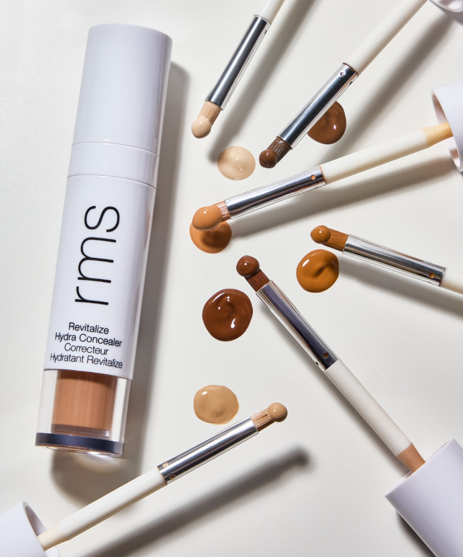 Revitalize Hydra Concealer with brushes and swatches showcasing a range of natural shades, highlighting clean beauty, natural ingredients, and cruelty-free makeup qualities.