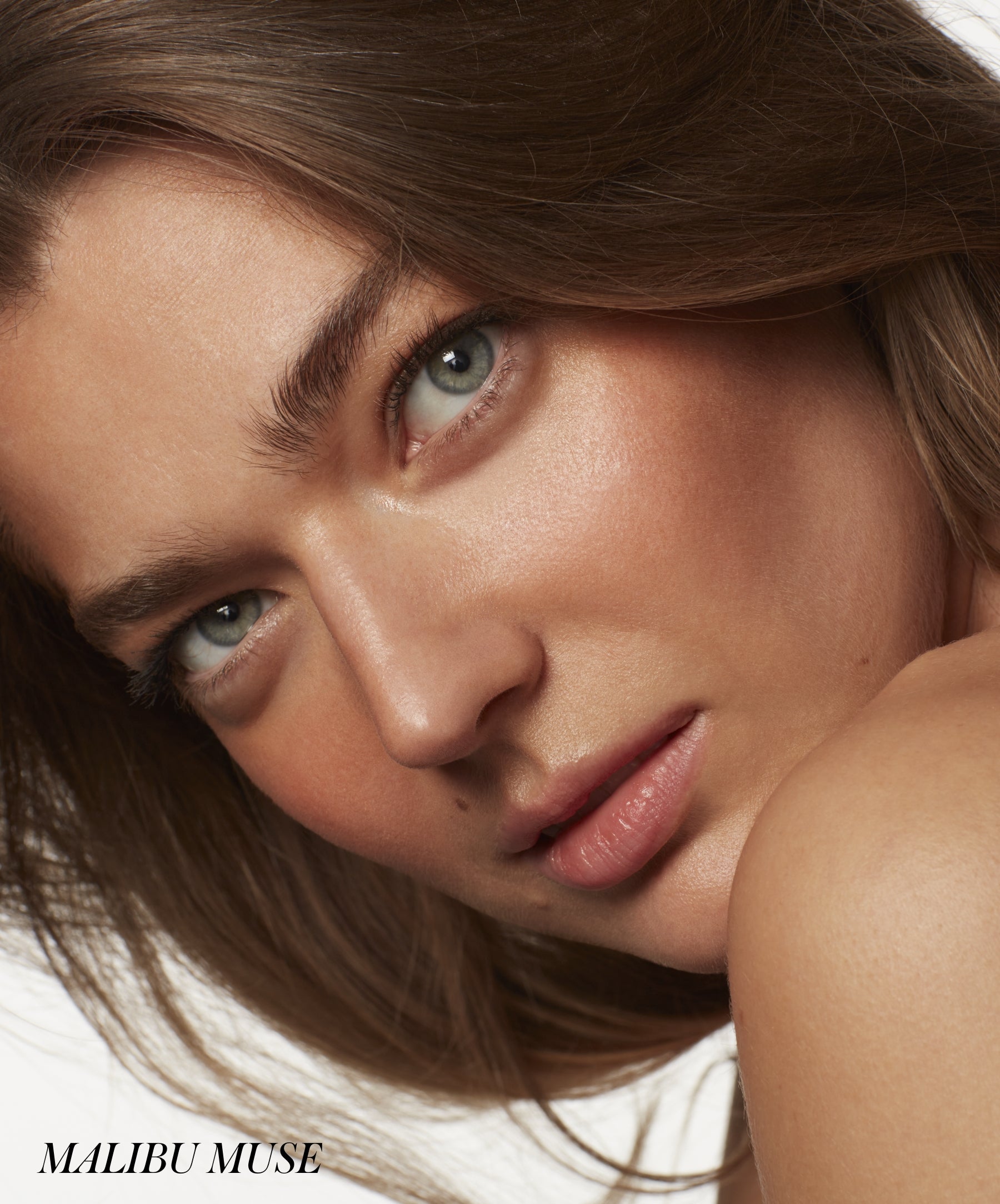 Close-up of a woman with natural glowing skin and soft makeup highlighting her complexion, showcasing the subtle radiance of ReDimension Hydra Bronzer.